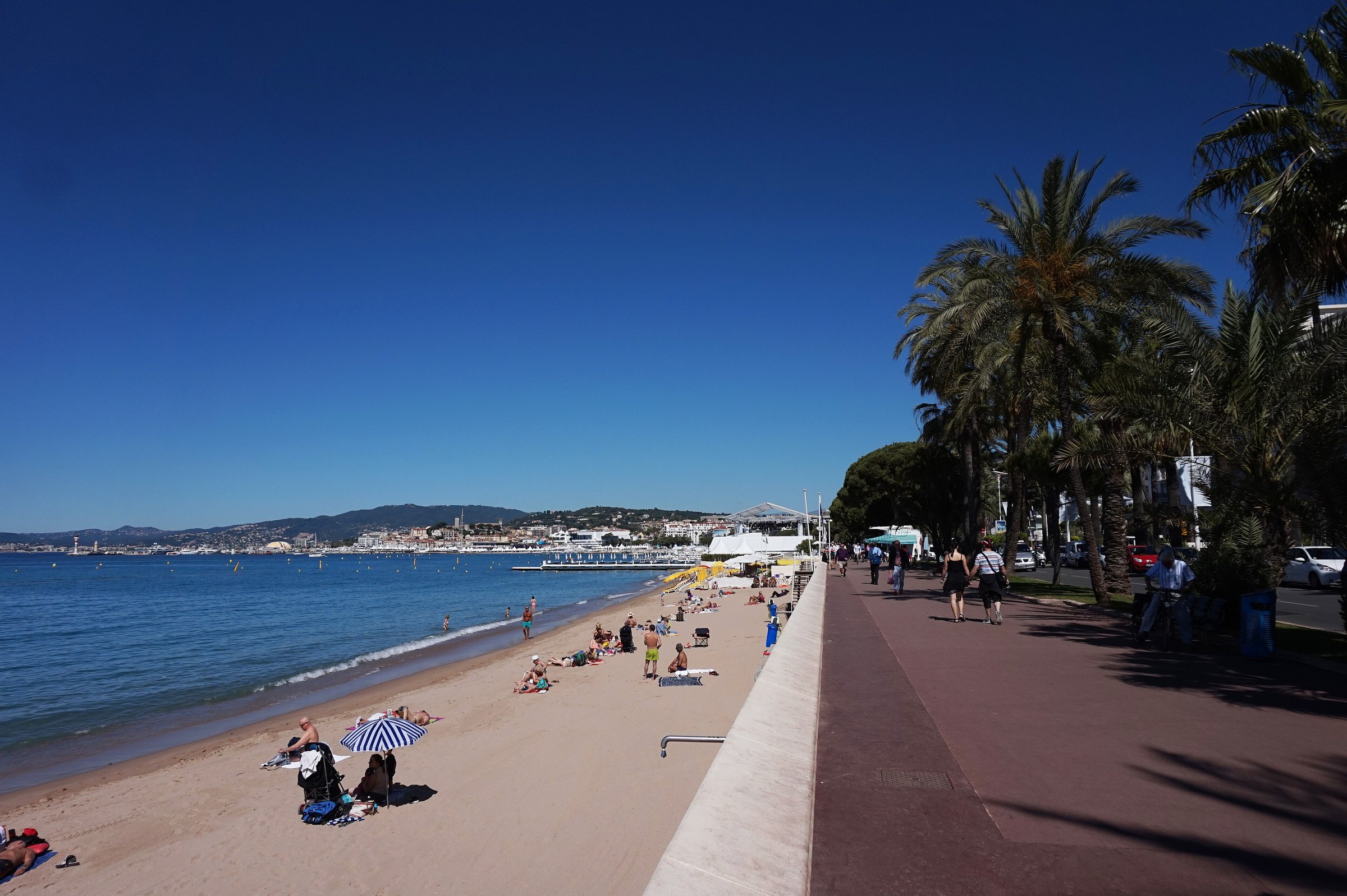 Boulevard de la Croisette mit Palmen und Strand in Cannes